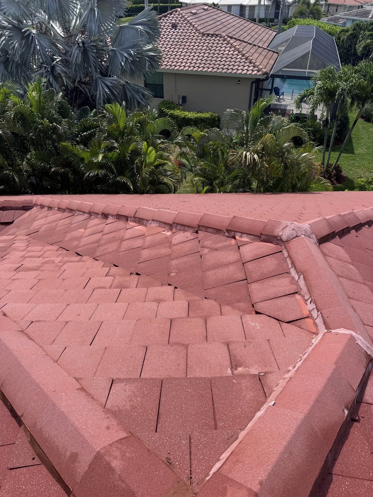 Red flat tile roof washed clean with the house behind it in Naples